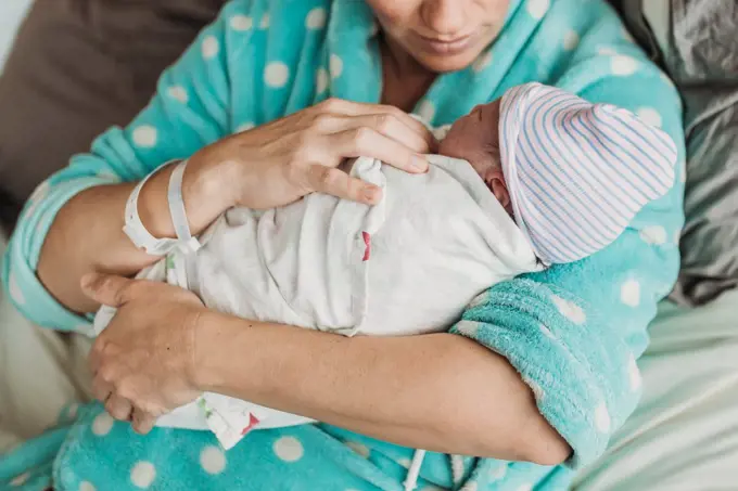 Close up image of mother holding newborn son right after birth