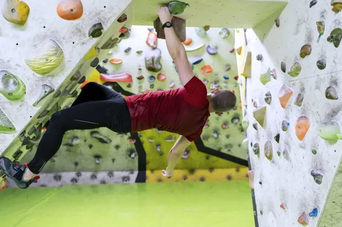 young man practicing climbing in the climbing wall