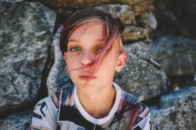 Boy With Pink Hair and Graphic Shirt Looks into the Camera