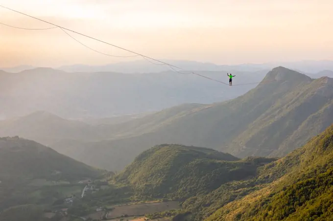 Slackliner standing on the line looking at the landscape