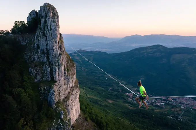 Slackliner sitting in the void waiting to walk the line