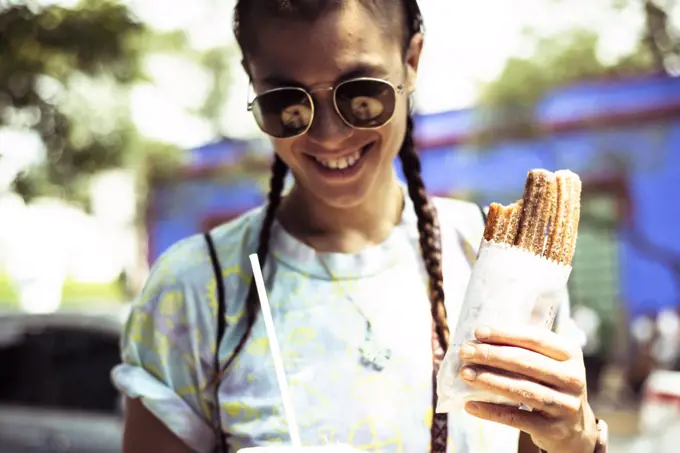 Smiling alternative hipster with churros outside Fridas House Mexico