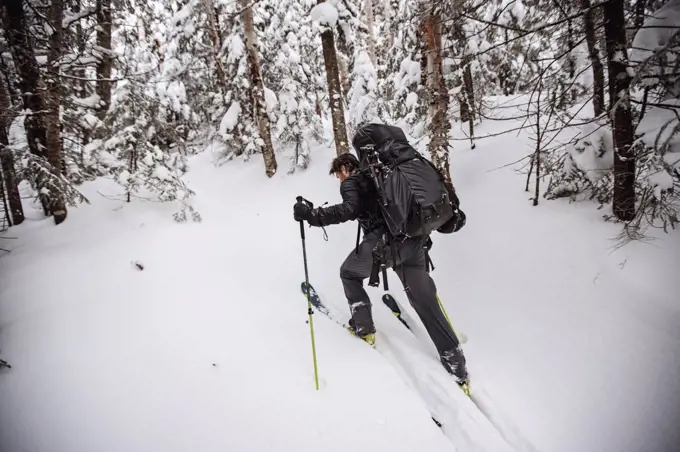 Make skier struggles with heavy pack skinning uphill in snow,