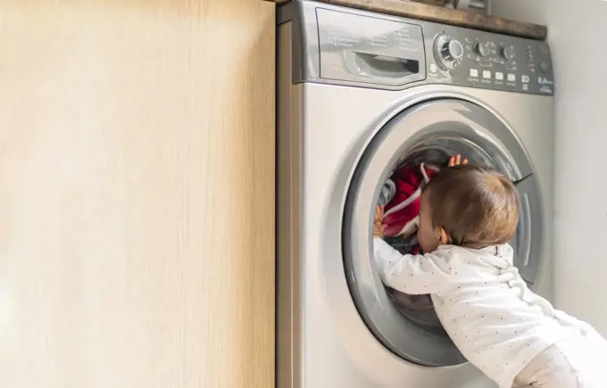 little girl looking at washing machine