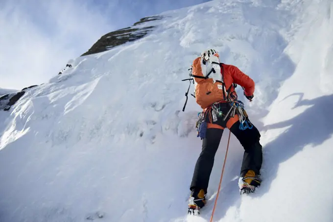 Male ice climbing guide leading an ice climb in New Hampshire