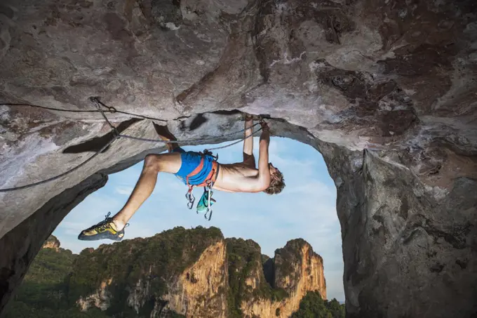 young man climbing overhanging rock face at Tonsai beach