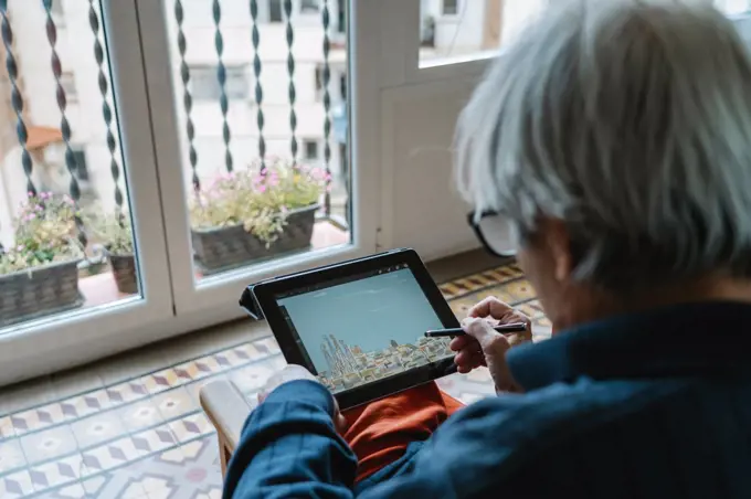 old man drawing with a tablet