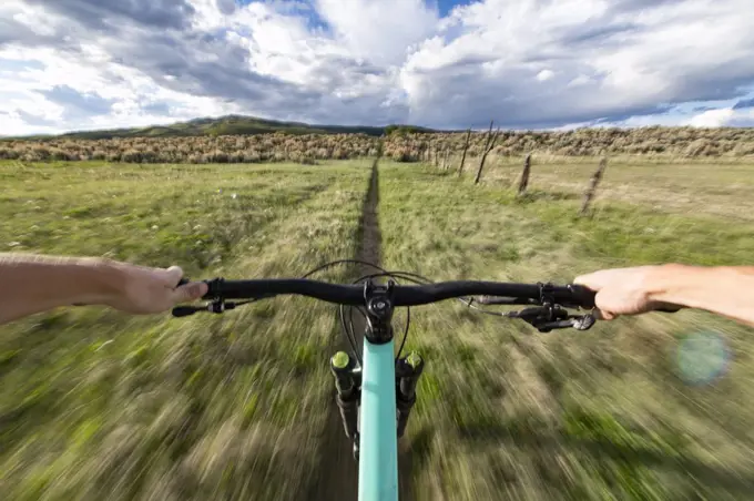 Cropped image of man riding bicycle on field