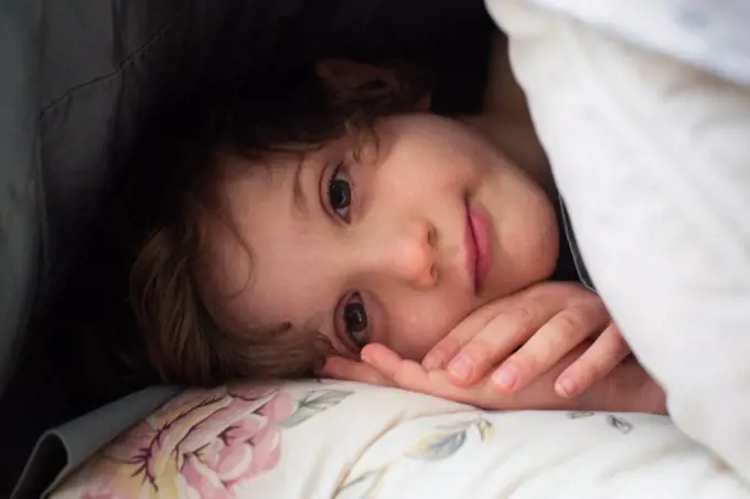 Front view of a cheerful boy laying down