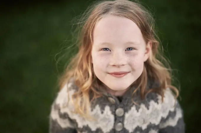 Happy freckled girl looking at camera