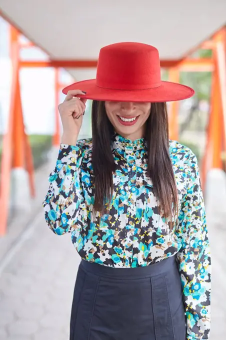 outdoor portrait of an attractive young Hispanic woman with red hat