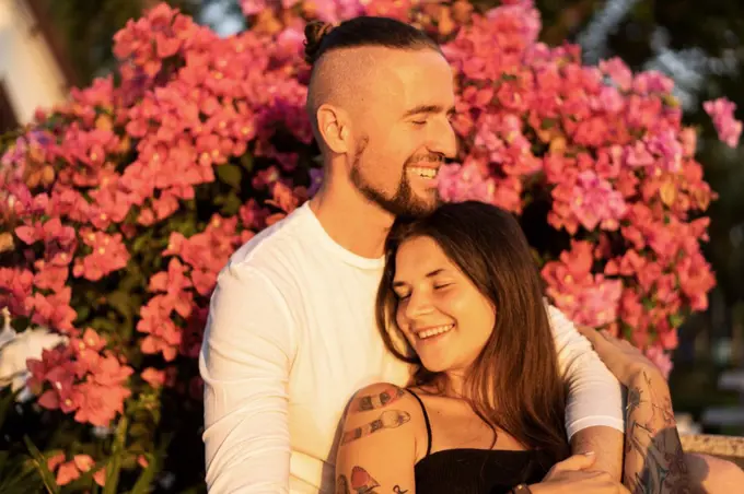 couple in love among flowers hugs and laughs