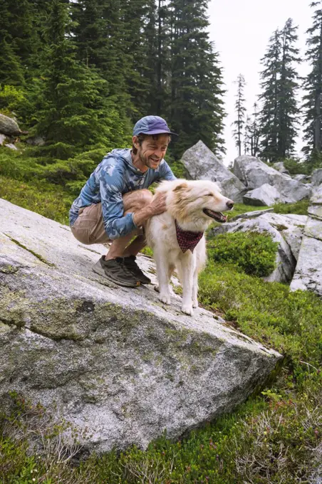 Fluffy dog getting pets and love from his dad in the backcountry