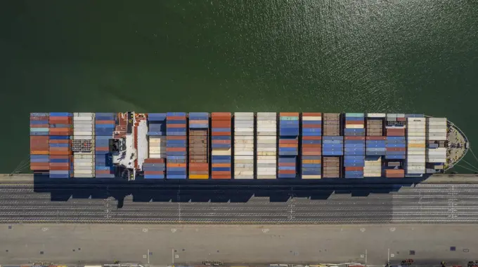 Aerial view of a fully loaded cargo ship docked at a port