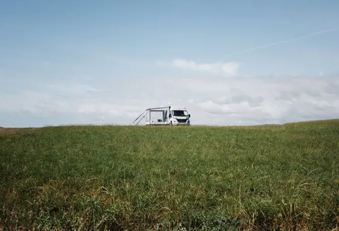 camper van alone in a large green open field in England