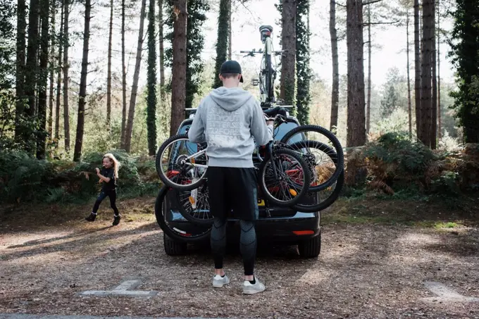 dad getting bikes off the car ready for a family bike ride