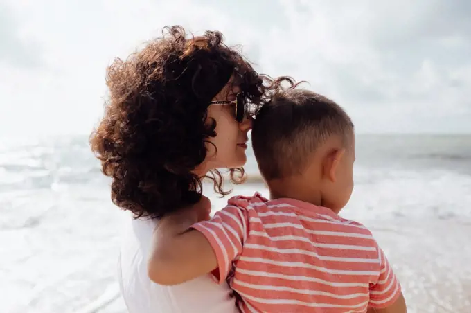 Young beautiful mommy ith her baby son on the beach