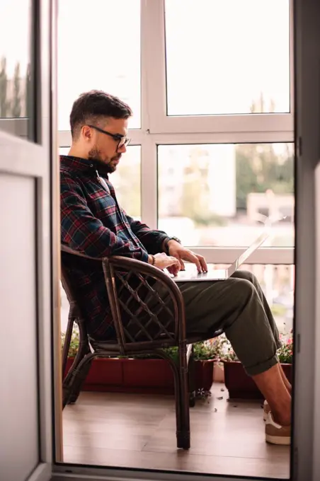 Man using laptop computer while working at home