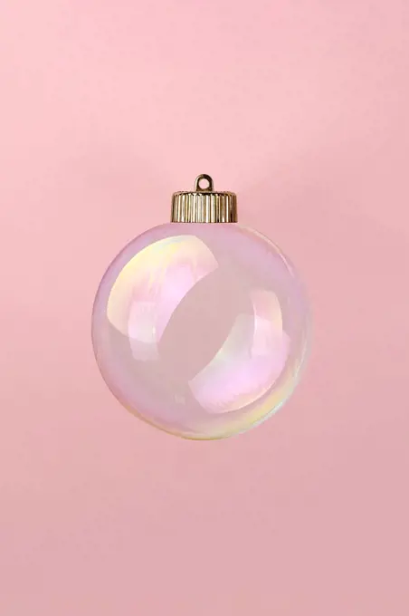 Christmas bauble decoration of soap bubble on pink. New year concept.