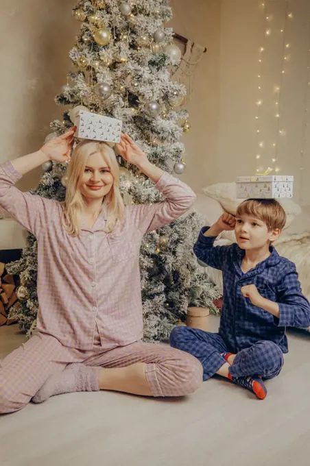 Mom and son with Santa's gifts under the Christmas tree.