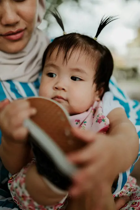 Mother holding baby girl in the park