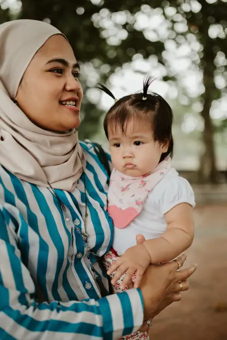 Mother holding baby girl in the park