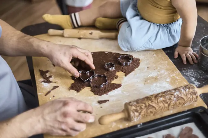 Dad cuts out chocolate chip cookies with a mold