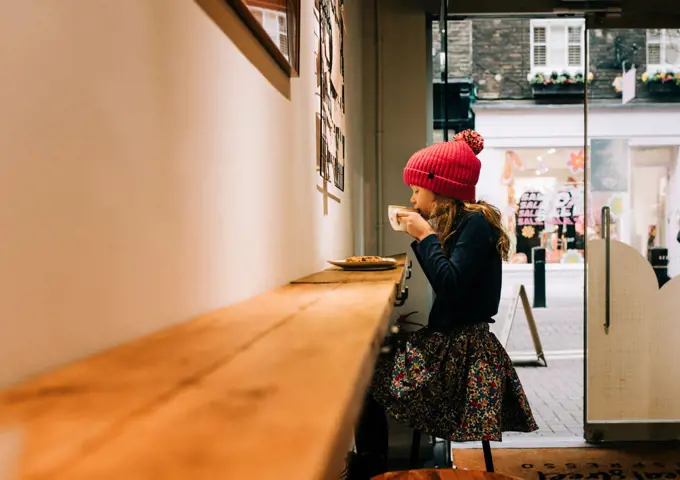 child sitting in a cafe in London enjoying a hot chocolate