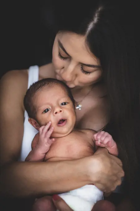 Mother with her new born kissing him on the heath