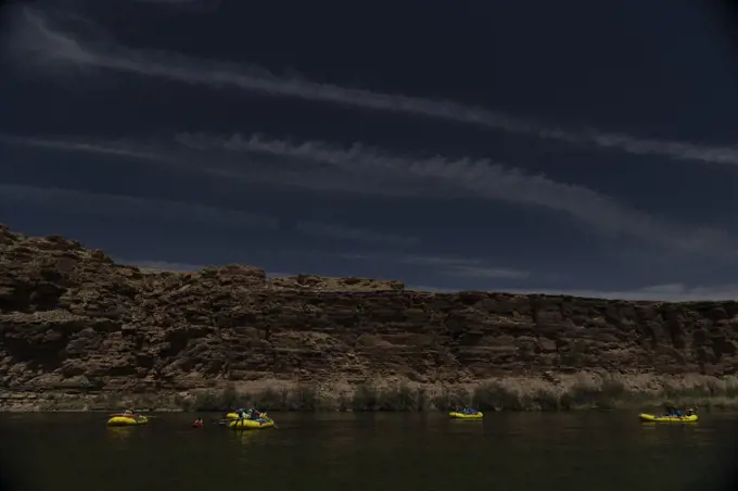 5 rafts floating down the Colorado River in the Grand Canyon