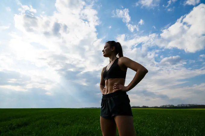 Girl athlete does warm-up outdoors, exercises for muscles