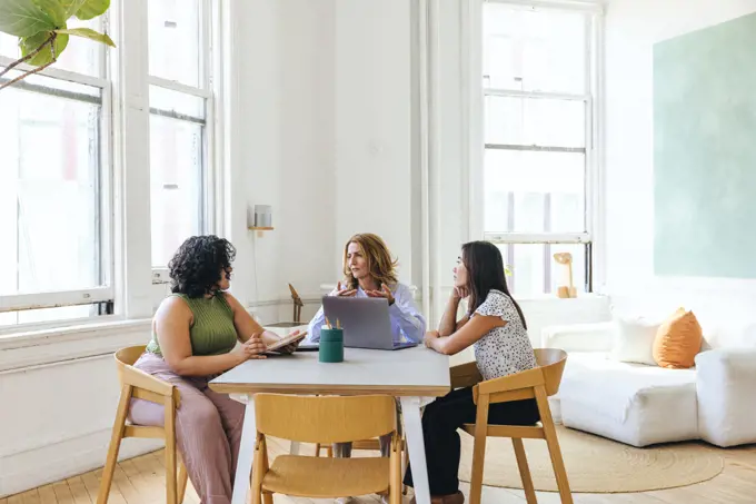 Multiracial businesswomen discussing business strategy at table