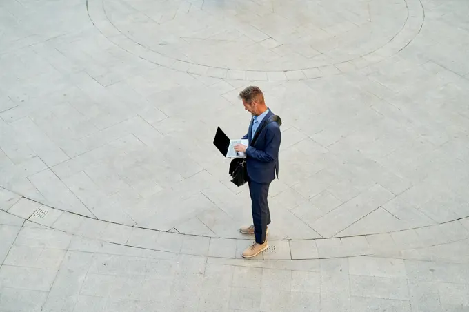 businessman working with computer in front of office building