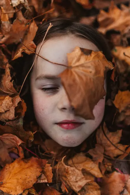 girl in a pile of leaves
