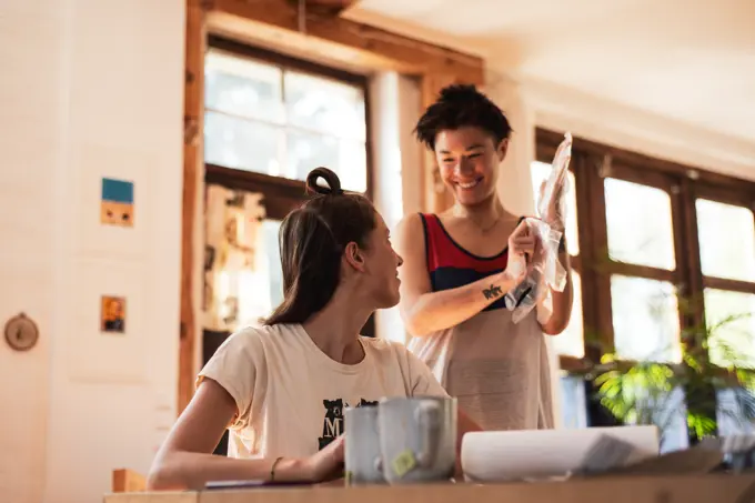 Queer couple laugh and smile together preparing to dye hair