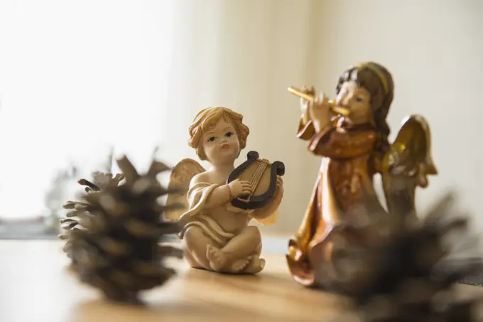 Decorative Christmas angel figurines with musical instruments and pine cone on the table, Bavaria, Germany