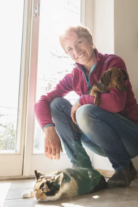 Mature woman with her pets at home, Bavaria, Germany