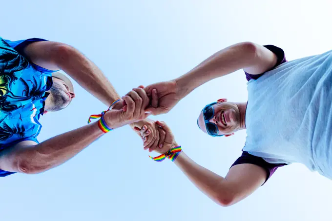 Gay couple holding hands while enjoying their vacation.