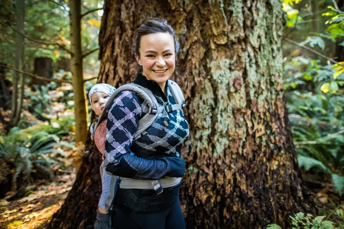 Healthy and fit mother wearing baby carrier, hiking