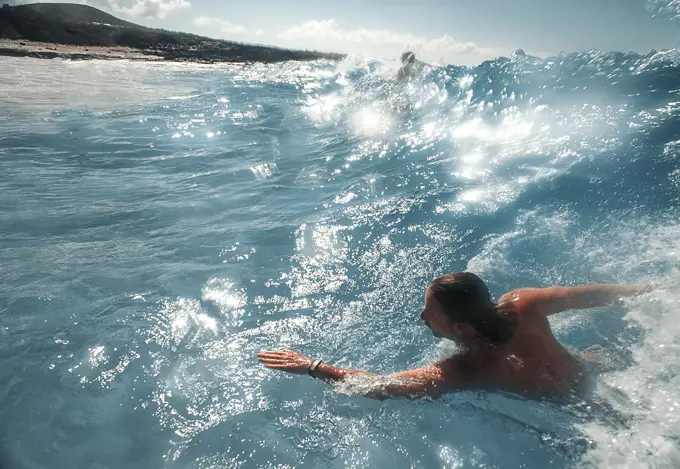 swimmer body surfs in hawaii