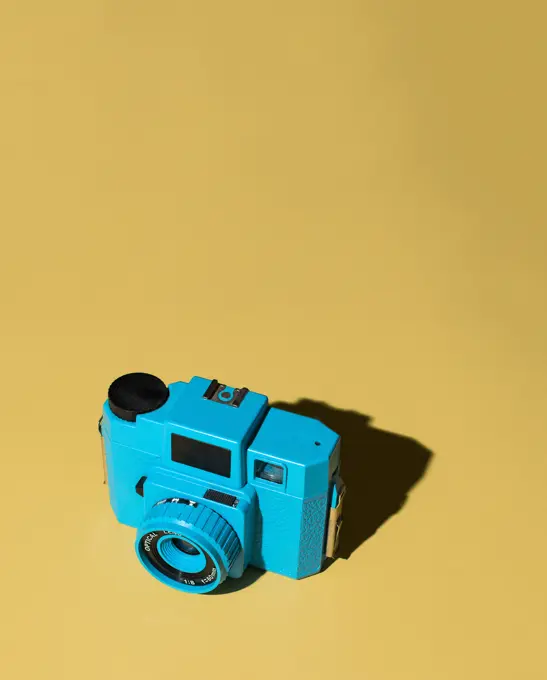 Blue Camera on Yellow Background