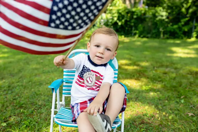 Toddler boy holding American flag wearing Patriotic shirt