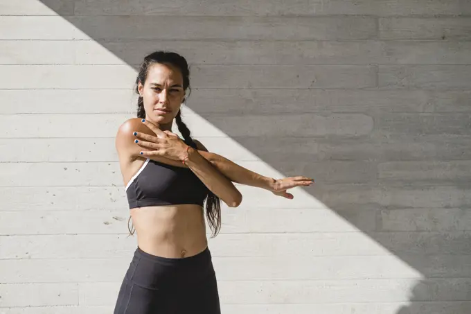 Upper body of female athlete stretching arms