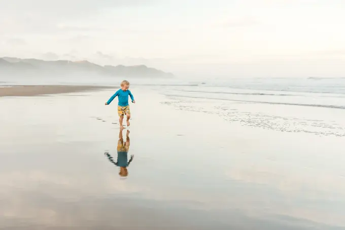 Child running on a beach in New Zealand