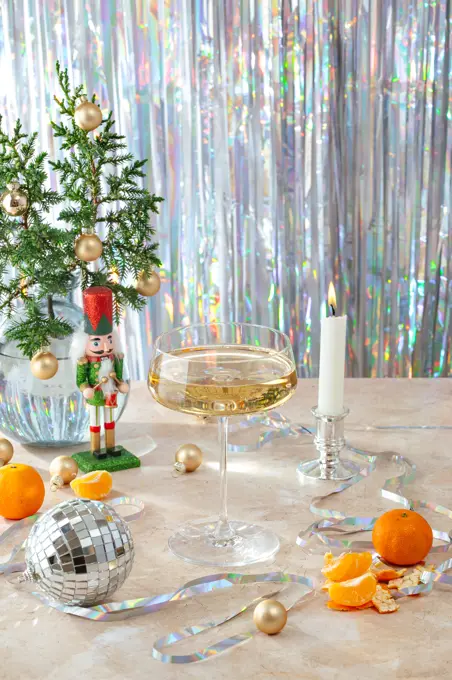 New Year's atmosphere, a glass of champagne, confetti, a lit candle