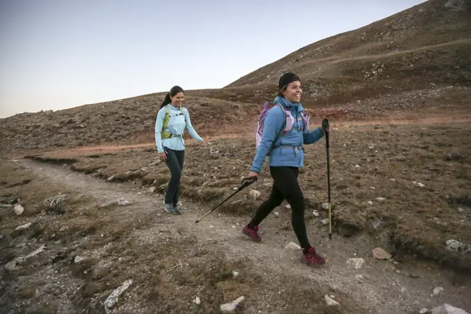 Two young women trail runners enjoy single track trail in the Rockies