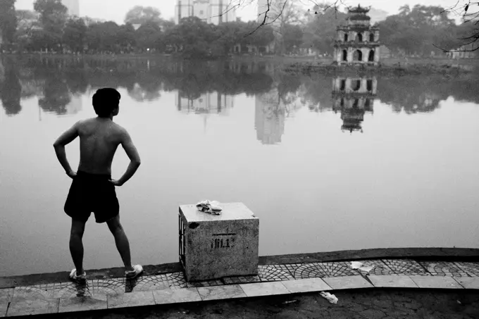 A local stretches at Hoan Kiem Lake, Hanoi, Vietnam.