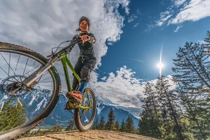 Woman mountain biking with mountains in the background