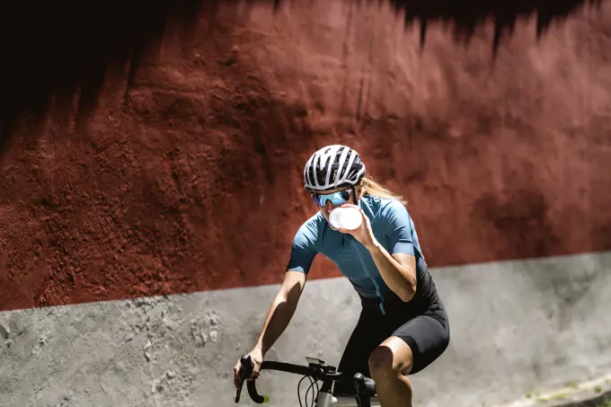 A female athlete drinks water on a city ride