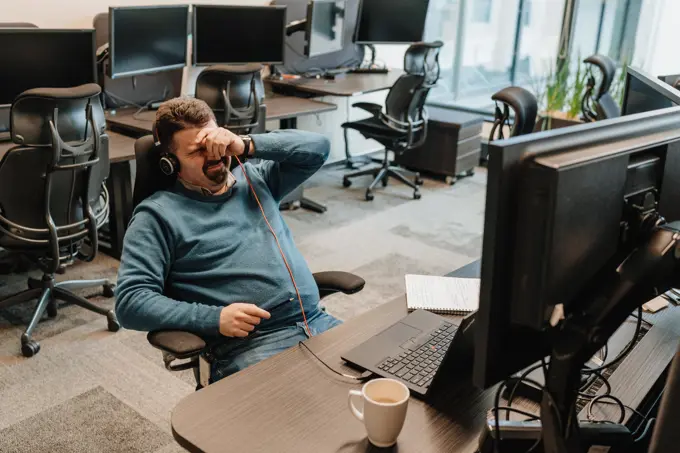 man is tired of working at the computer and wants to go on vacation